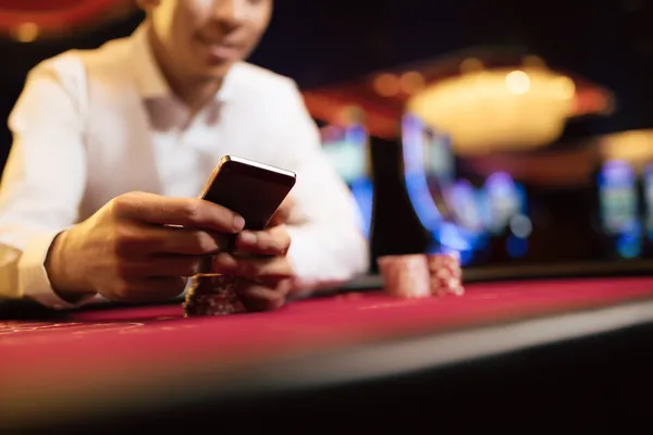 A young woman relaxing with her phone while dynamic casino elements float around her, illustrating the smooth mobile experience offered by the HI76 app.